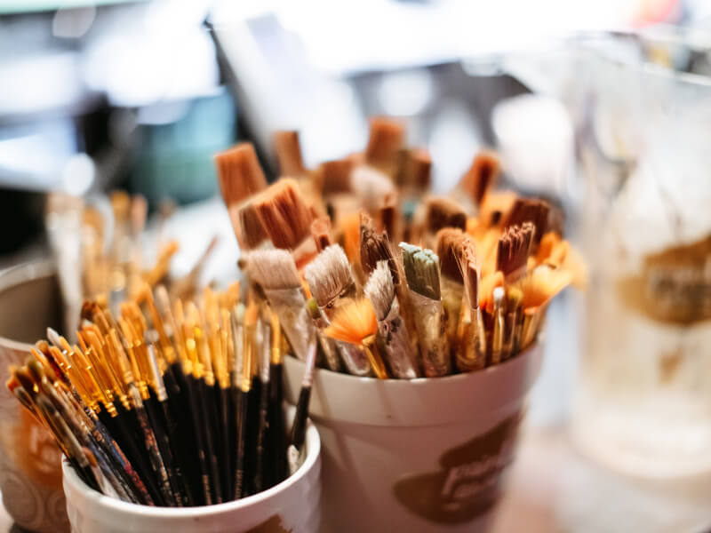 Pots of paintbrushes in a painting class